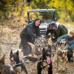 a group of people standing next to a dog