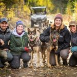a group of people sitting on a bench posing for the camera