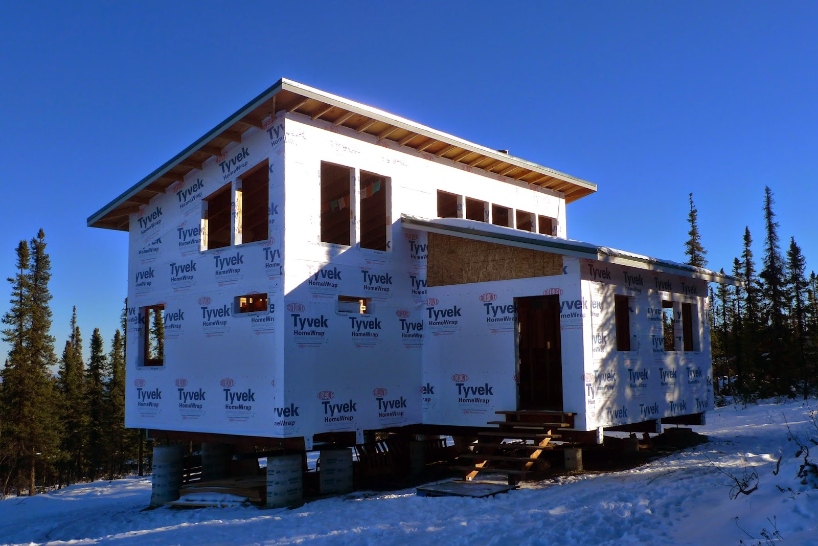 a truck is parked in front of a house covered in snow